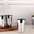 Stainless steel kitchen utensils set of four tumblers on a countertop