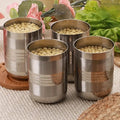 Set of four stainless steel kitchen utensil containers filled with soybeans